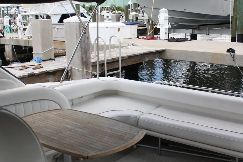 Knot Ez II Yacht Photos Pics 1998 Sea Ray 450 Sundancer yacht interior with white seating and wooden table at marina.