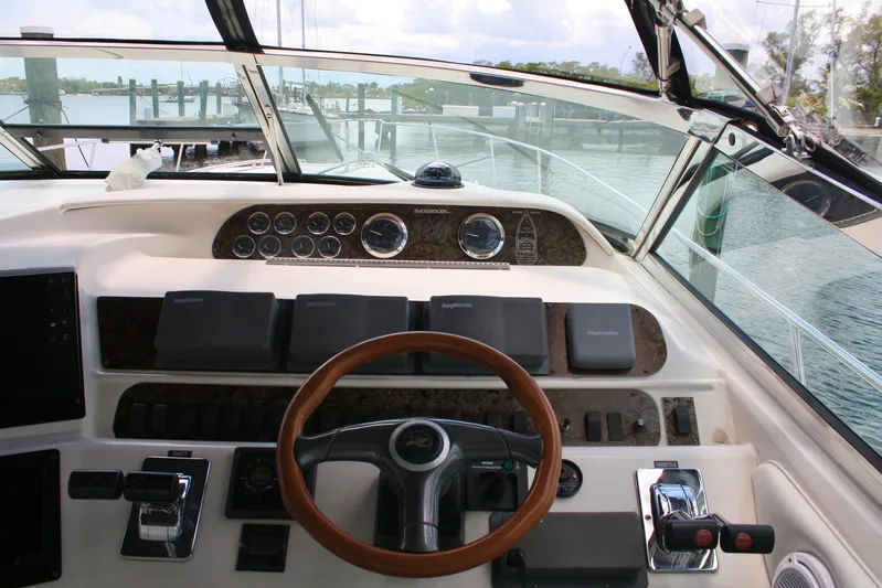 Knot Ez II Yacht Photos Pics 1998 Sea Ray 450 Sundancer helm with wooden steering wheel and navigational controls.