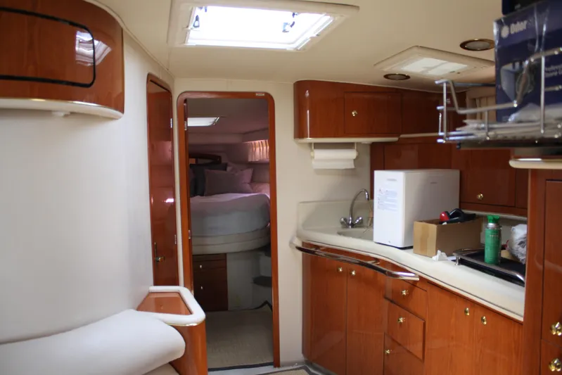 Knot Ez II Yacht Photos Pics 1998 Sea Ray 450 Sundancer interior with wood cabinetry and cozy bedroom.