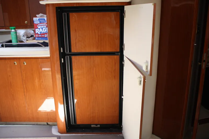 Knot Ez II Yacht Photos Pics 1998 Sea Ray 450 Sundancer interior with wooden cabinetry and open storage compartment.