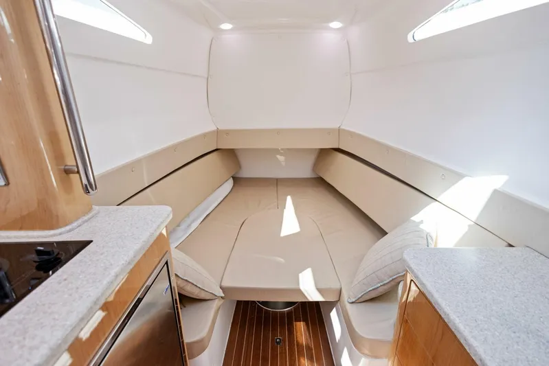  Yacht Photos Pics 2015 Intrepid 475 Panacea cabin interior with beige seating and wooden flooring.