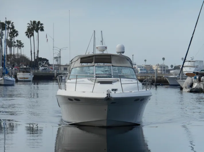 Cygnus Yacht Photos Pics 2000 Sea Ray Sundancer 410 yacht docked in a marina with palm trees in the background.