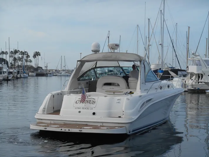 Cygnus Yacht Photos Pics 2000 Sea Ray Sundancer 410 yacht docked in marina, calm waters, clear sky.