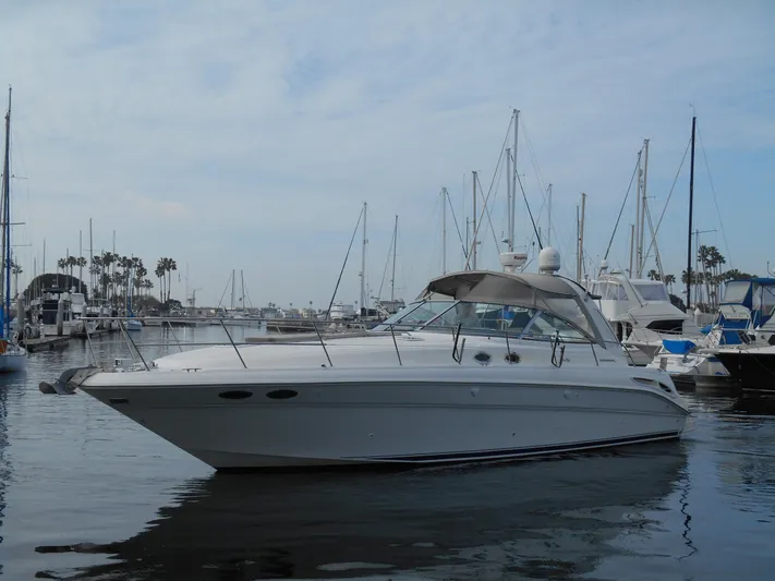 Cygnus Yacht Photos Pics 2000 Sea Ray Sundancer 410 yacht docked in a marina with sailboats.