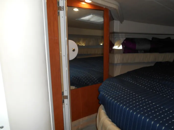 Cygnus Yacht Photos Pics Interior cabin of 2000 Sea Ray Sundancer 410 with blue bedding and wooden door.
