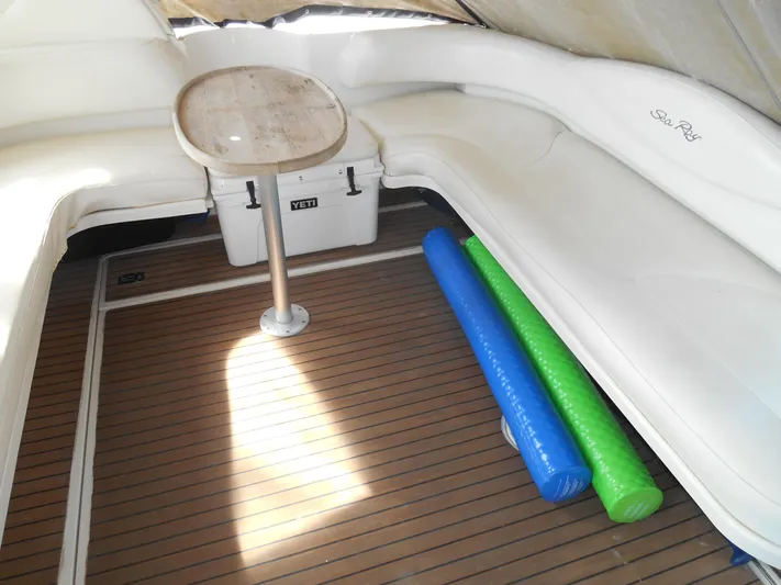 Cygnus Yacht Photos Pics 2000 Sea Ray Sundancer 410 interior with seating, table, and colorful pool noodles.