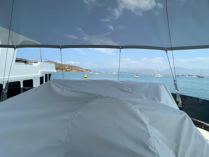  Yacht Photos Pics 2024 Beneteau Swift Trawler 41 Fly, covered deck view, overlooking serene ocean and anchored boats.