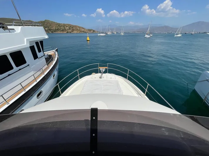  Yacht Photos Pics 2024 Beneteau Swift Trawler 41 Fly docked, surrounded by serene waters and sailboats.