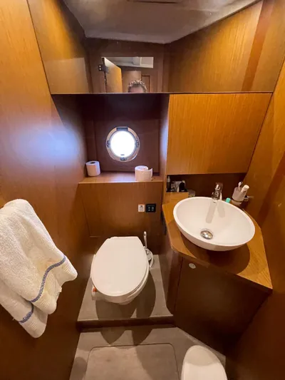  Yacht Photos Pics 2024 Beneteau Swift Trawler 41 Fly bathroom with modern fixtures and porthole window.