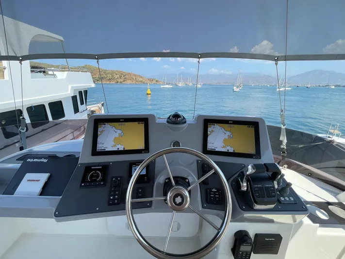  Yacht Photos Pics 2024 Beneteau Swift Trawler 41 Fly helm with dual navigation screens, steering wheel, and sea view.