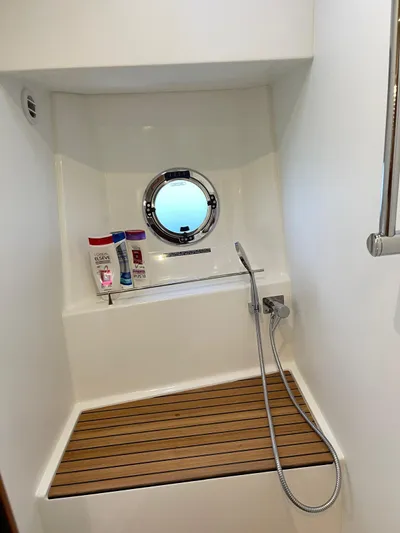  Yacht Photos Pics 2024 Beneteau Swift Trawler 41 Fly shower with porthole and wooden bench.