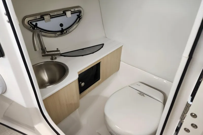  Yacht Photos Pics Compact bathroom in 2025 Regal LX4 boat with sink and toilet.