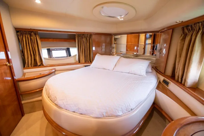  Yacht Photos Pics Luxurious bedroom interior of a 2007 Azimut 62 yacht with elegant wood finishes.