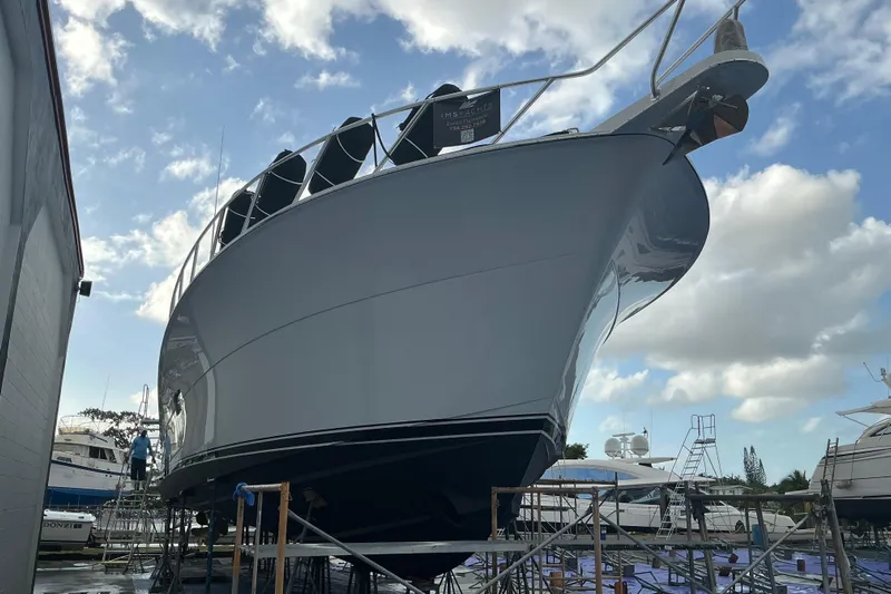  Yacht Photos Pics 2016 Hatteras GT63 yacht on dry dock under a partly cloudy sky.
