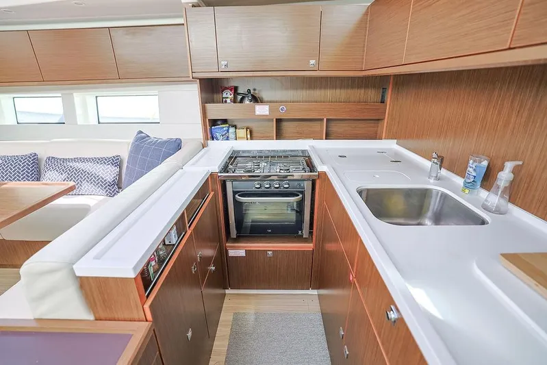 Das Boot Yacht Photos Pics Modern kitchen interior on 2020 Bavaria C57 yacht with wood cabinetry and stainless steel sink.