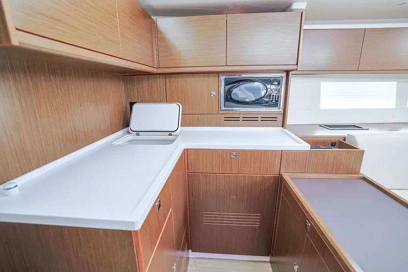 Das Boot Yacht Photos Pics Modern kitchen interior in 2020 Bavaria C57 yacht, featuring wood cabinetry and built-in microwave.
