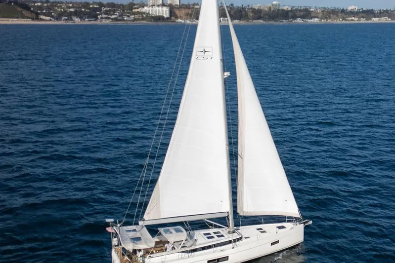 Das Boot Yacht Photos Pics 2020 Bavaria C57 sailboat cruising on open sea with coastal background.