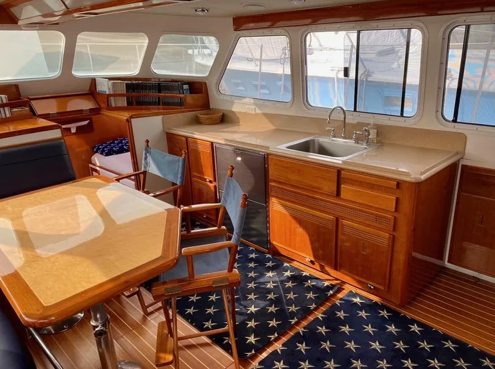 Following Sea Yacht Photos Pics Interior of a 1965 Bertram 56 yacht with wooden cabinetry and nautical decor.