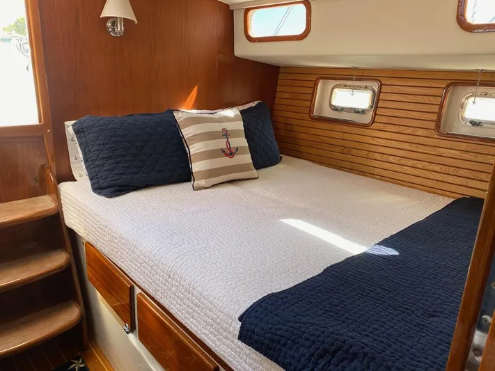 Following Sea Yacht Photos Pics Cozy cabin interior of a 1965 Bertram 56 yacht with nautical-themed bedding.