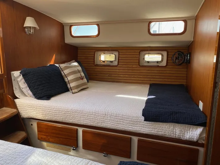 Following Sea Yacht Photos Pics Cozy cabin interior of a 1965 Bertram 56 yacht with wooden accents and nautical decor.