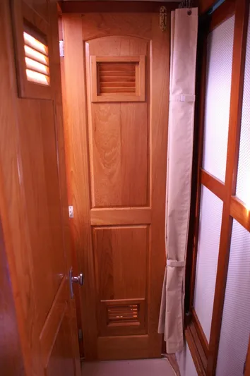 Following Sea Yacht Photos Pics Wooden interior door on a 1965 Bertram 56 yacht, featuring louvered panels.