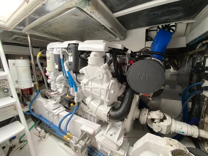 Following Sea Yacht Photos Pics Engine room of a 1965 Bertram 56 yacht with CAT machinery and blue hoses.