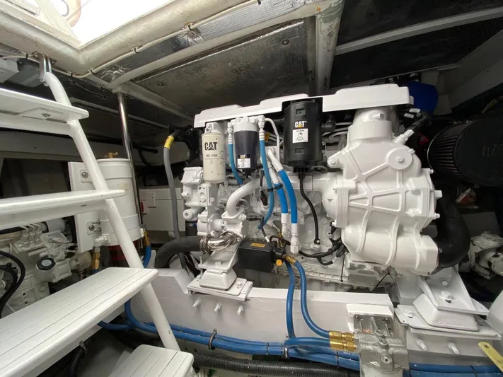 Following Sea Yacht Photos Pics Engine room of a 1965 Bertram 56 yacht with CAT machinery and white interior.