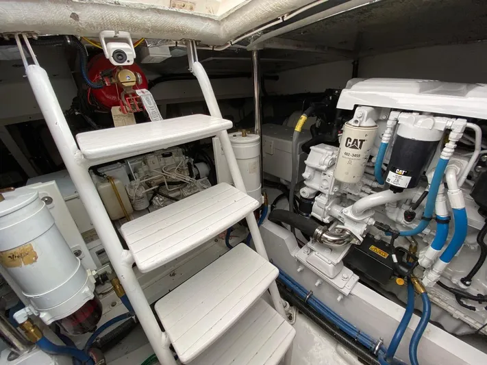 Following Sea Yacht Photos Pics Engine room of a 1965 Bertram 56 boat with CAT machinery and white ladder.