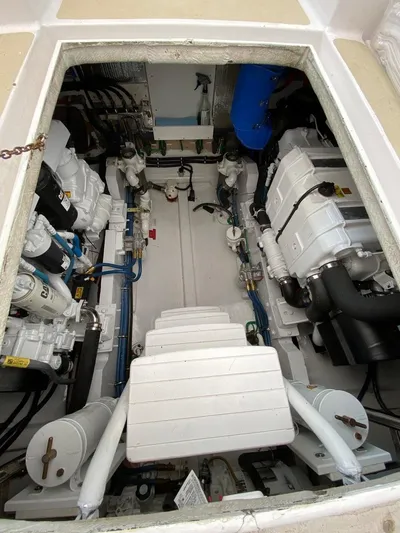 Following Sea Yacht Photos Pics Engine room of a 1965 Bertram 56 boat, showcasing dual engines and mechanical components.