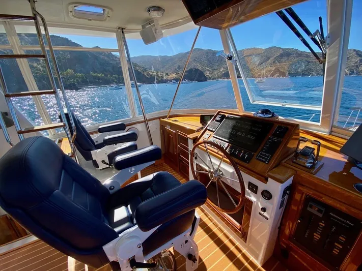 Following Sea Yacht Photos Pics Interior of a 1965 Bertram 56 yacht with scenic ocean view through windows.