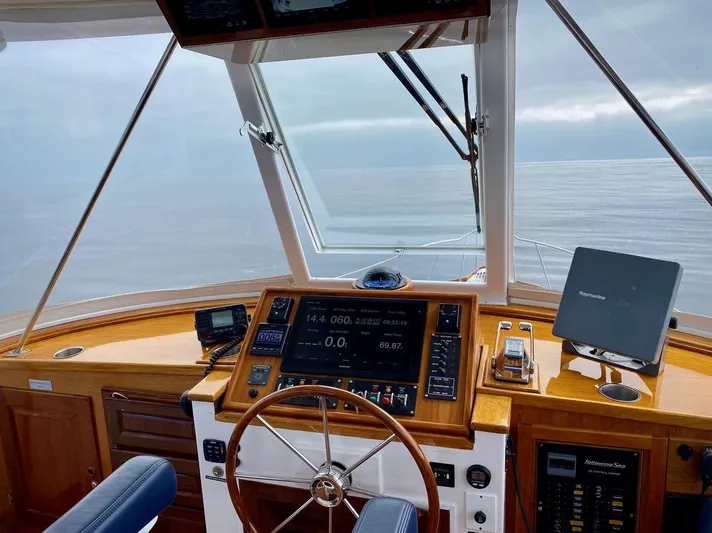 Following Sea Yacht Photos Pics Helm of a 1965 Bertram 56 yacht with navigation equipment and ocean view.
