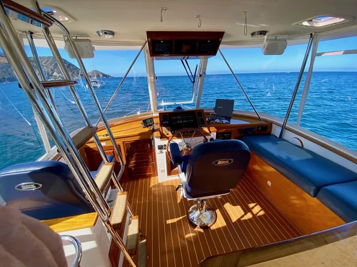 Following Sea Yacht Photos Pics Interior of a 1965 Bertram 56 yacht with ocean view and wooden flooring.