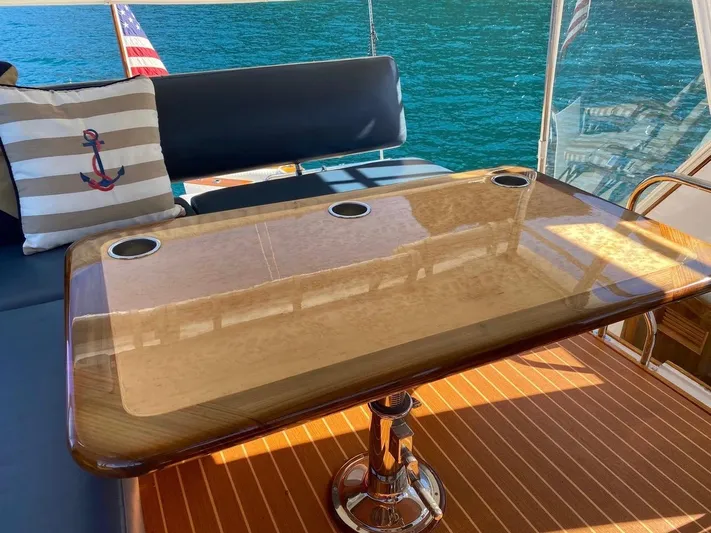Following Sea Yacht Photos Pics Luxurious interior of a 1965 Bertram 56 yacht with polished table and nautical decor.