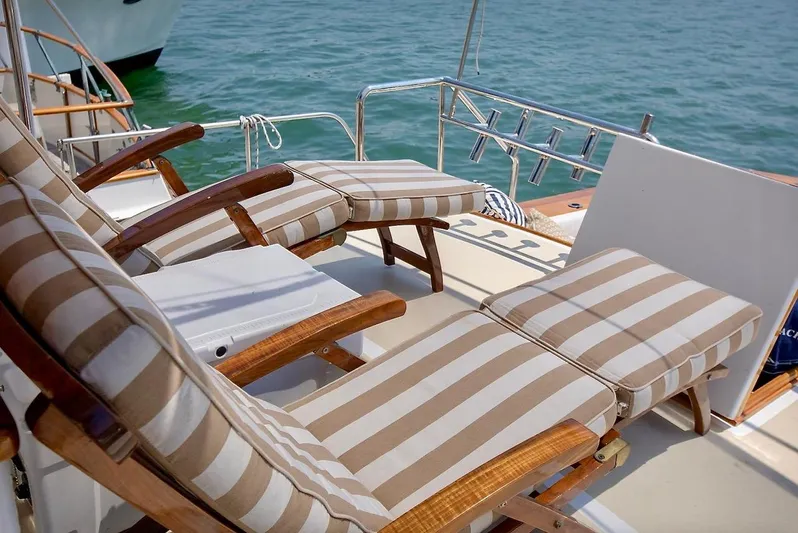 Following Sea Yacht Photos Pics Striped lounge chairs on a 1965 Bertram 56 yacht deck by the sea.