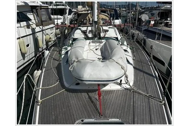  Yacht Photos Pics 2004 Jeanneau Sun Odyssey 54 DS sailboat with dinghy on deck, docked in marina.