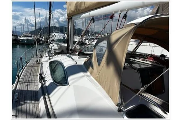  Yacht Photos Pics 2004 Jeanneau Sun Odyssey 54 DS sailboat docked in a marina, showcasing deck and canopy.