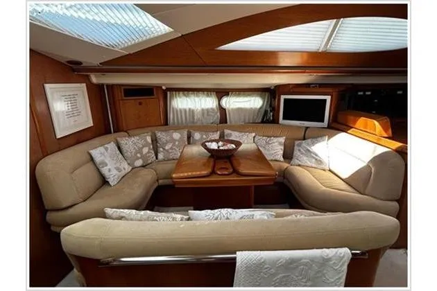  Yacht Photos Pics Luxurious interior of 2004 Jeanneau Sun Odyssey 54 DS yacht with plush seating and elegant decor.