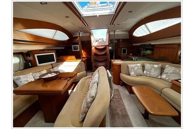  Yacht Photos Pics Luxurious interior of 2004 Jeanneau Sun Odyssey 54 DS yacht with elegant seating and skylight.