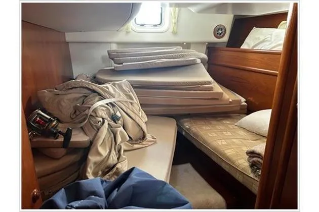  Yacht Photos Pics Cabin interior of 2004 Jeanneau Sun Odyssey 54 DS with stacked cushions and bedding.