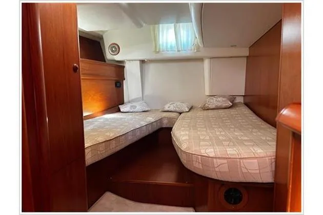  Yacht Photos Pics Interior cabin of 2004 Jeanneau Sun Odyssey 54 DS with twin beds and wooden finish.