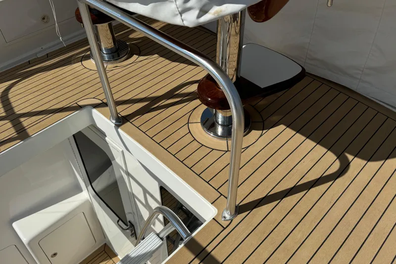 Ella Mae Yacht Photos Pics Henriques 42 Flybridge 2011 boat deck with polished metal railings and wooden flooring.