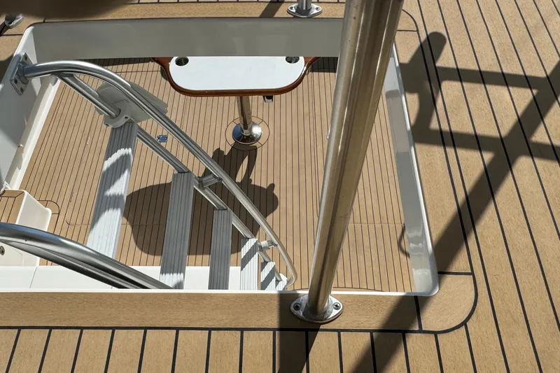 Ella Mae Yacht Photos Pics Henriques 42 Flybridge 2011 boat deck with ladder and table, featuring wood finish.