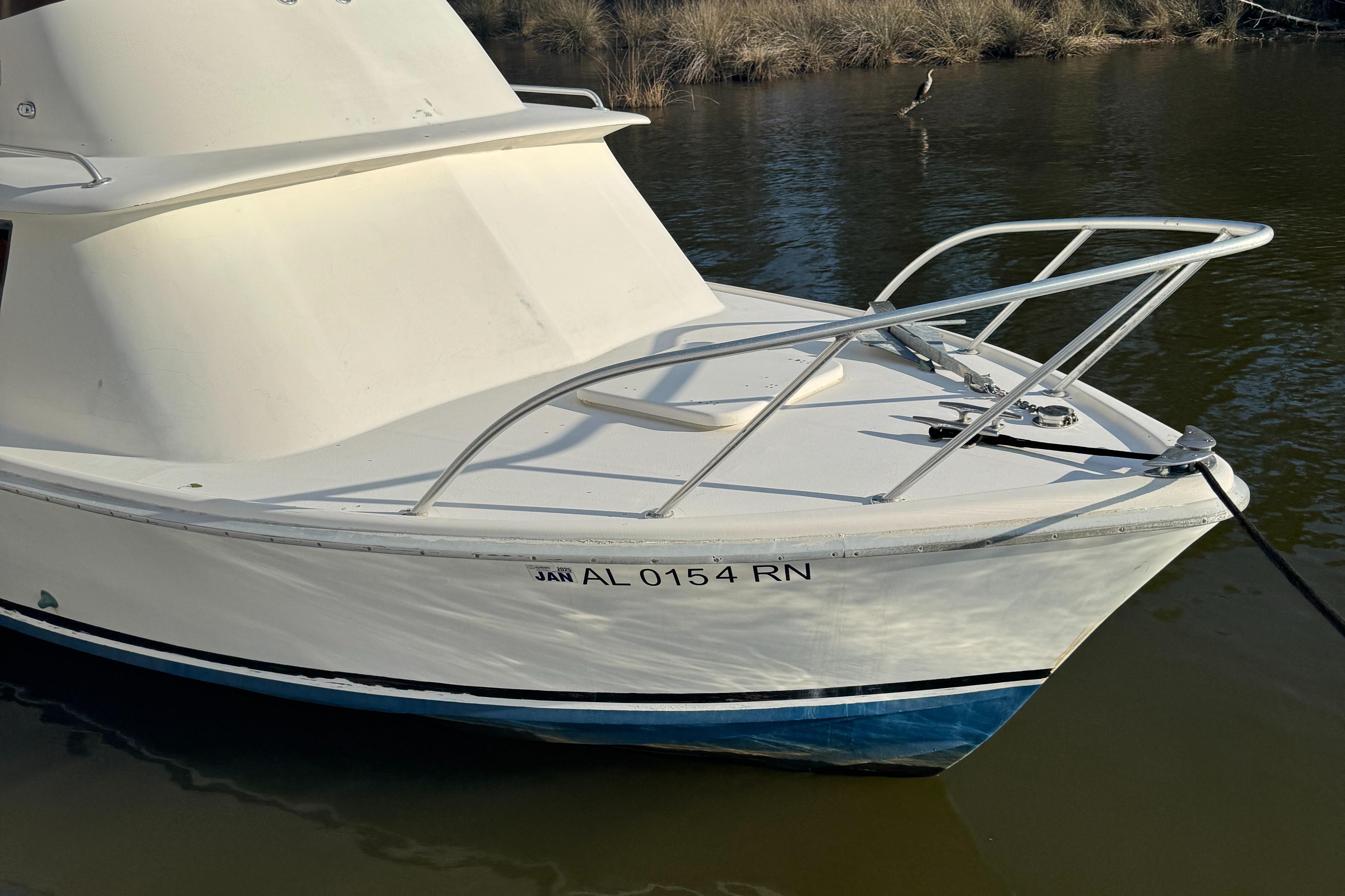 1974 Bertram 31 Flybridge boat on water, white hull, registration AL 0154 RN.