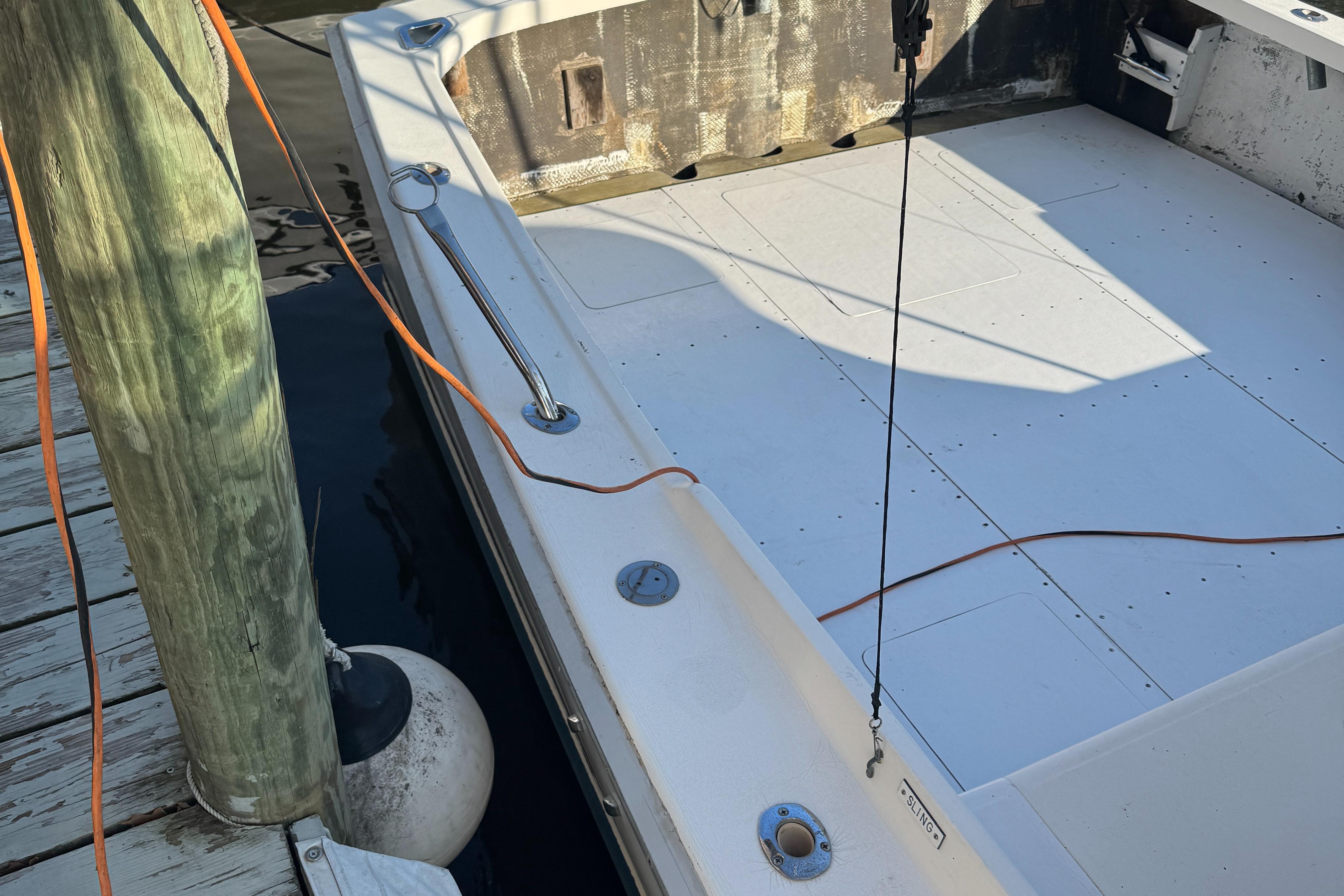 1974 Bertram 31 Flybridge boat docked, showing spacious deck and mooring lines.