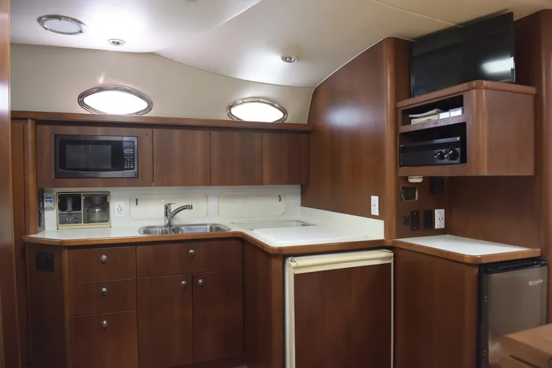 Sprout Yacht Photos Pics 1995 Tiara Yachts 4000 Express kitchen with wood cabinetry, microwave, sink, and mini-fridge.