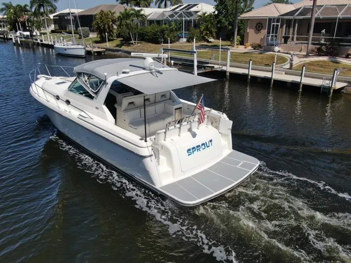 Sprout Yacht Photos Pics 1995 Tiara Yachts 4000 Express cruising in a canal near waterfront homes.