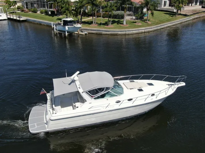 Sprout Yacht Photos Pics 1995 Tiara Yachts 4000 Express cruising in a canal near waterfront homes.