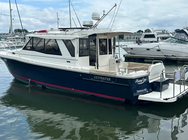  Yacht Photos Pics 2014 Cutwater C-30 Sedan boat docked in a marina, featuring a sleek design and spacious deck.
