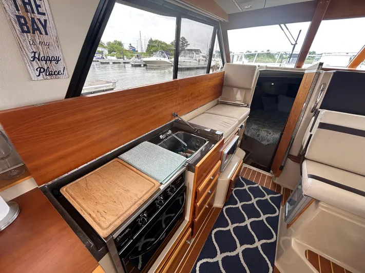  Yacht Photos Pics Interior of 2014 Cutwater C-30 Sedan boat with kitchen and seating area.