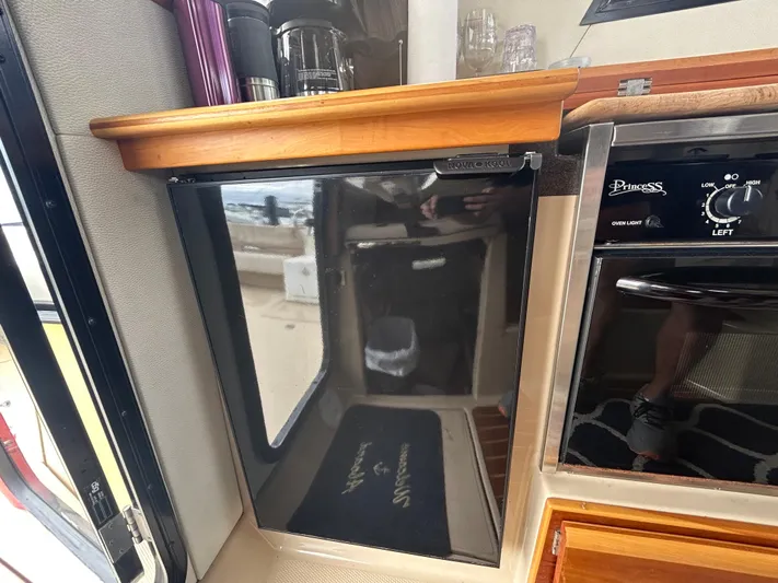  Yacht Photos Pics 2014 Cutwater C-30 Sedan interior with compact kitchen appliances and wooden cabinetry.